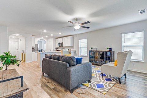 a living room with a couch and a ceiling fan